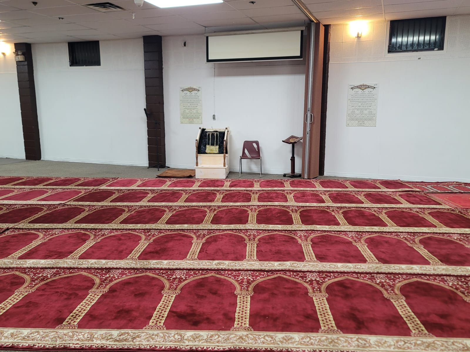Main prayer hall of the Muslim Association of Woodstock with traditional red prayer carpets